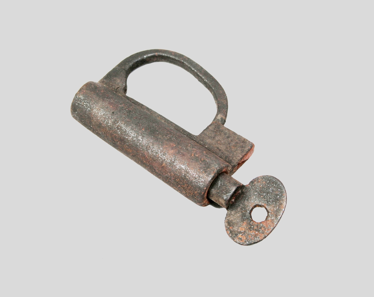 Cylindriskt låshus, med valvformad bygel och nyckel.