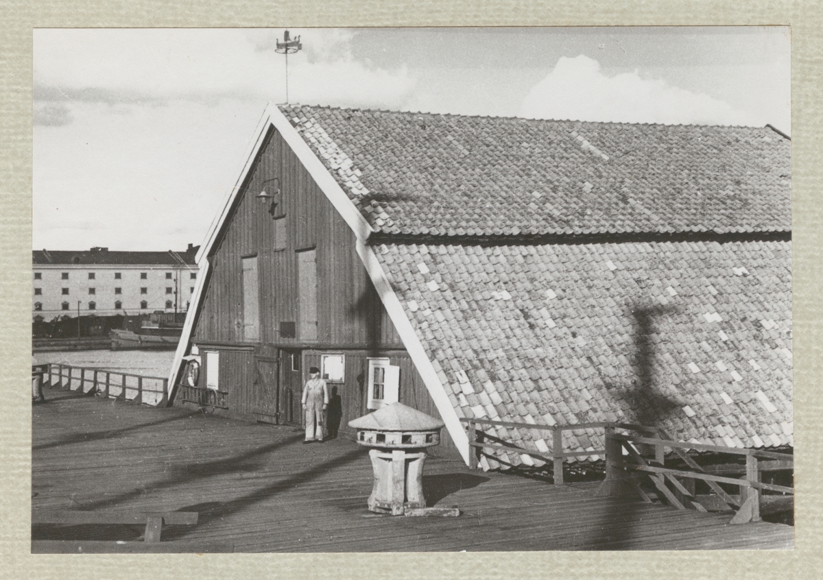 En ensam varvsarbetare står framför gamle Kranboden på Karlskronavarvet. I bildens mitt syns ett gammalt gångspill.
