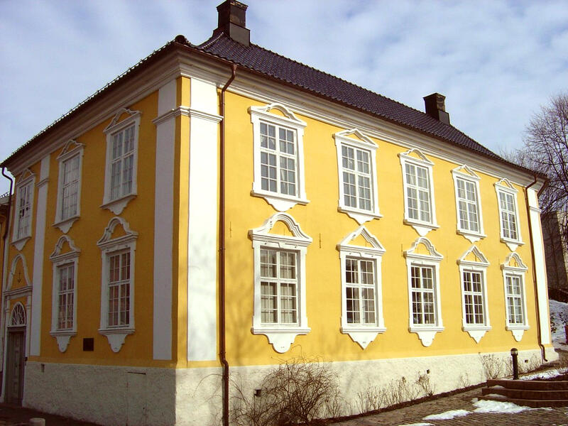 Foto av hovedbygningen ved Moss Jernverk. Huset er et staslig to-etasjes murhus malt i gult med hvite vinduskarmer og utsmykninger
