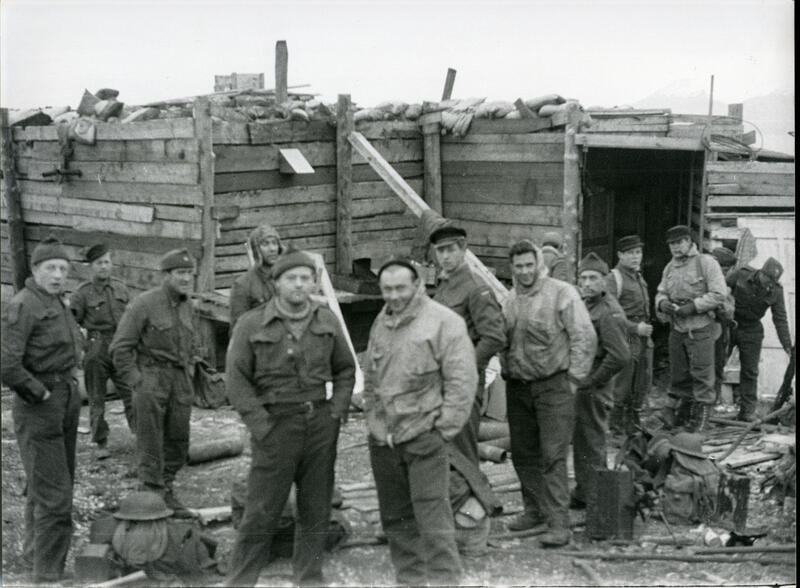 En gruppe soldater, med en provisorisk hytte i bakgrunnen.