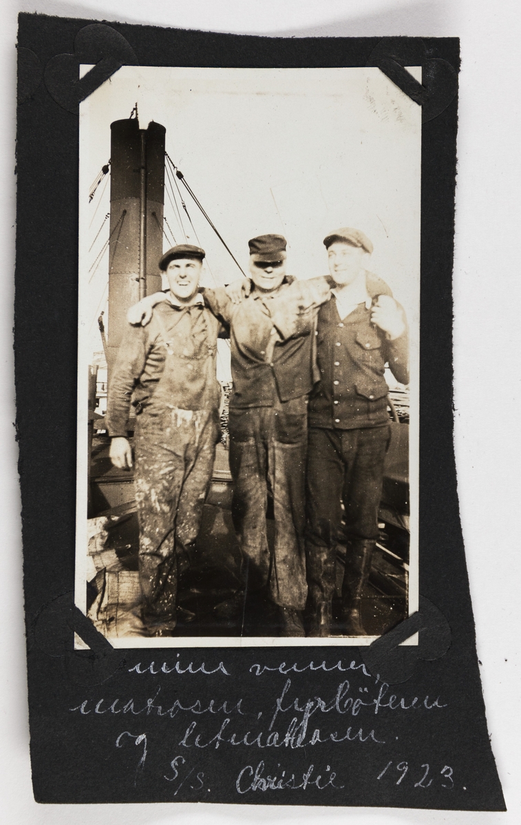 Tre menn i arbeidstøy smiler til fotografen på dampskipet D/S "Christie".