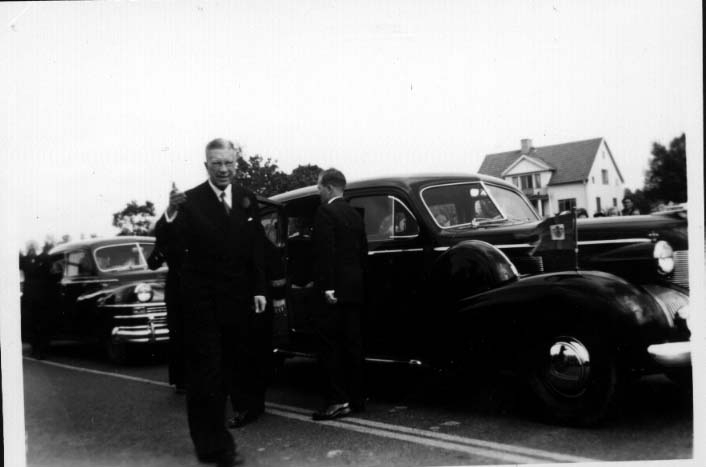 Två parkerade bilar. Vid den första bilden står kung Gustaf VI Adolf. Foto i samband med Eriksgata.