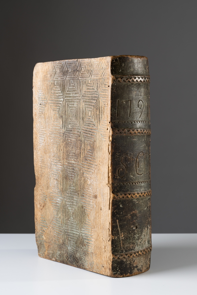 Kryddlåda av trä i bokform, ornerad. På ryggen skuret "1791" och "S C D".