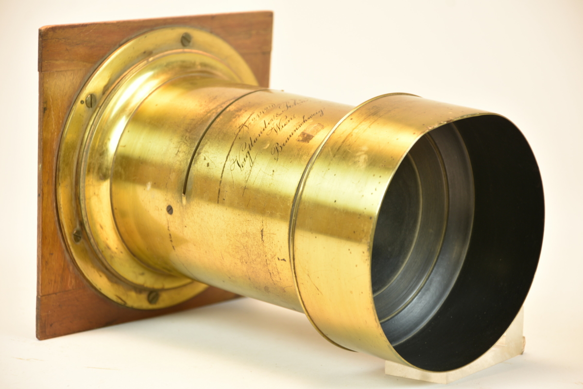 Objektiv, så kallad Petzval-kanon avsedd att användas med en så kallad insticksbländare. Objektivet har serienummer 21424.