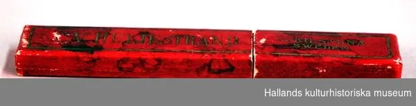 Rakkniv av stål. I röd ask (b), med firmatexten "C.V: Heljestrand, Eskilstuna Sweden". b) En röd ask.