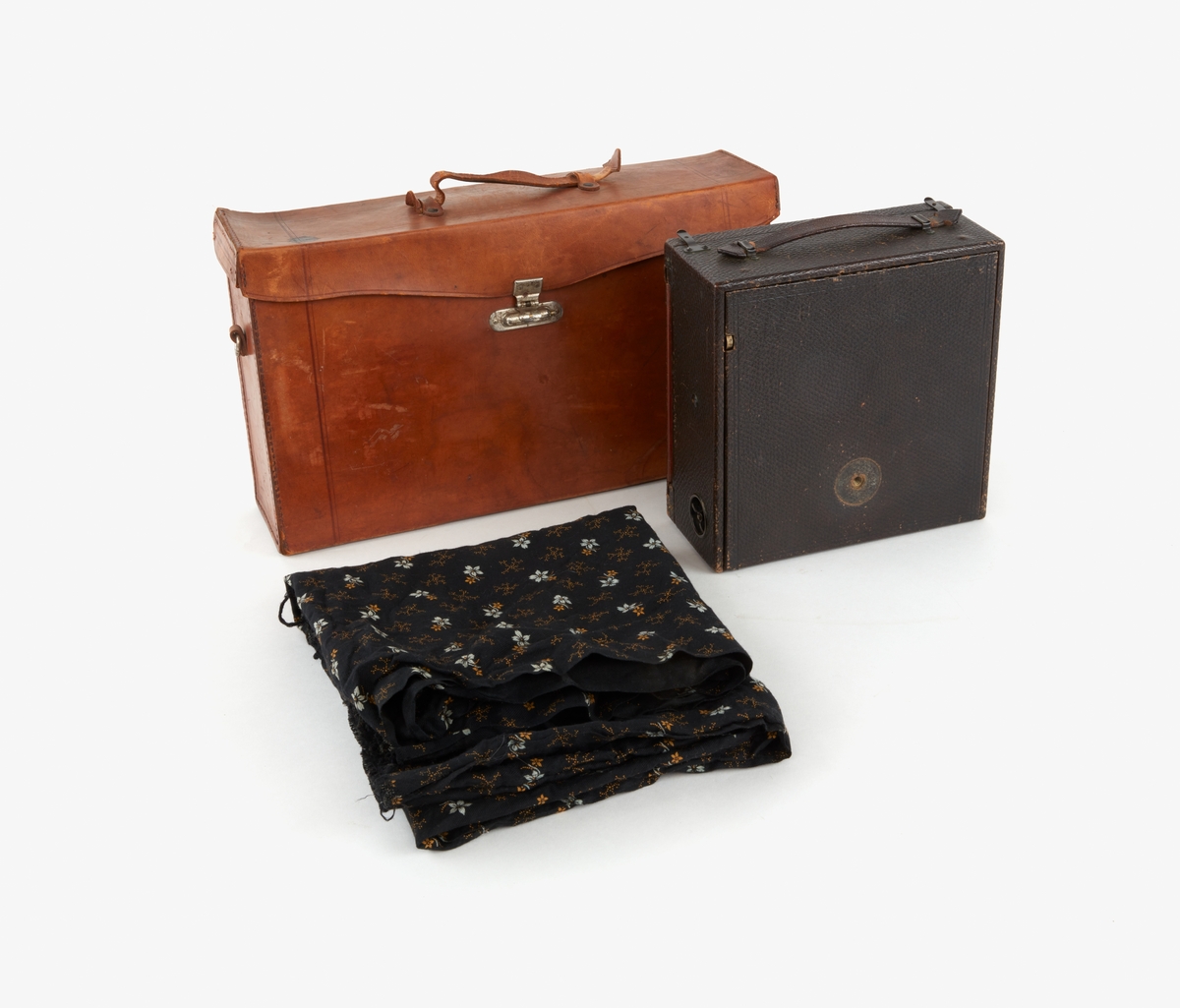 Portabel bälgkamera som förvaras i en svart låda som ligger i väska av ljust skinn. Text: TELE-PHOTO POCO. Väskan saknar axelrem.