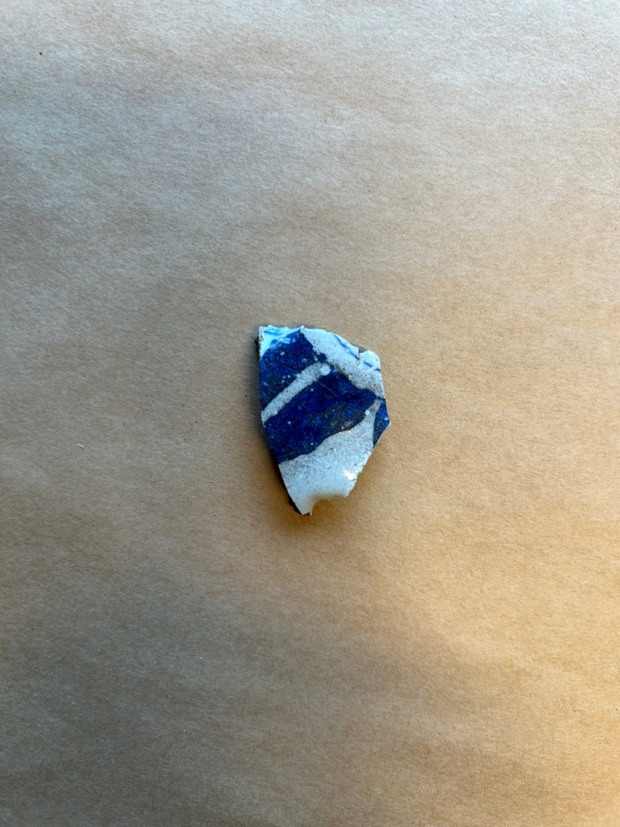 Ett fragment av fajans med blå dekor.