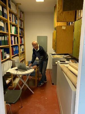 Mann registrerer arkiv i arkivrom