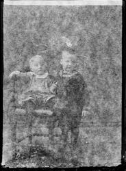 To barn fotografert i studio. Barnet til venstre er kledd i 