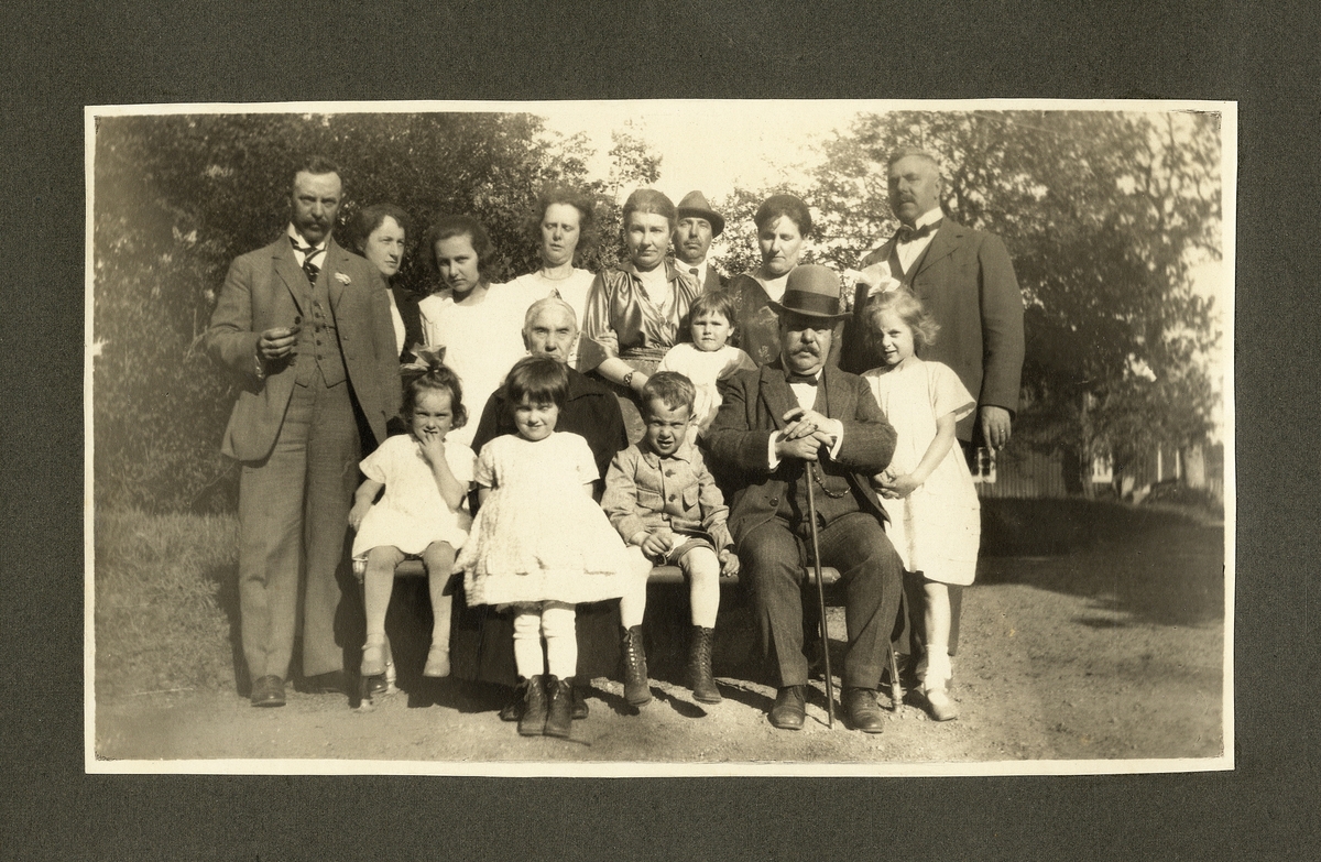 Släkten Ljunggren i trädgården på undantaget Kristinero, Kylhult, en varm sommardag. Den gamla damen i mitten är trol. fru Ingrid Kristina Ljunggren (1841-1929), omgiven av barn och barnbarn.