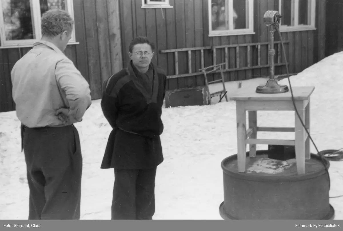 En mann, muligens Lydolf Lind Meløy, på denne tiden skoleinspektør i Karasjok, og Per Hætta (til høyre) i 1949-1950 i Karasjok. Per Hætta var en kunstner og kunsthåndverker. Mikrofonen er satt opp på stolen.