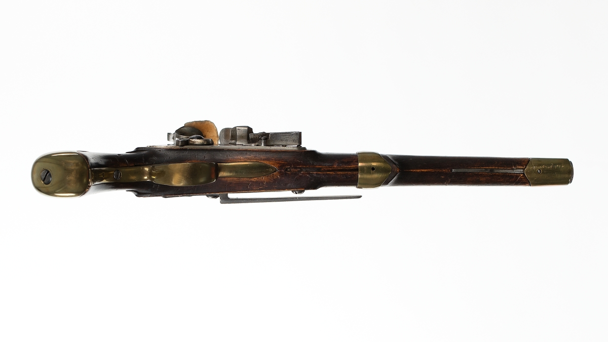 Pistol med flintlås, troligen förändringsmodell av år 1807 eller 1808. Stocken av trä, brun. Pipa och mekanism av stål. Beslagen av mässing. Kammarstycket 5-kantigt, märkt AH med krona över och därunder H och NT. På sidan GN.
