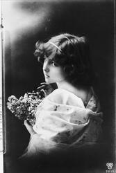 Postkort med bilde av ung dame med blomster.