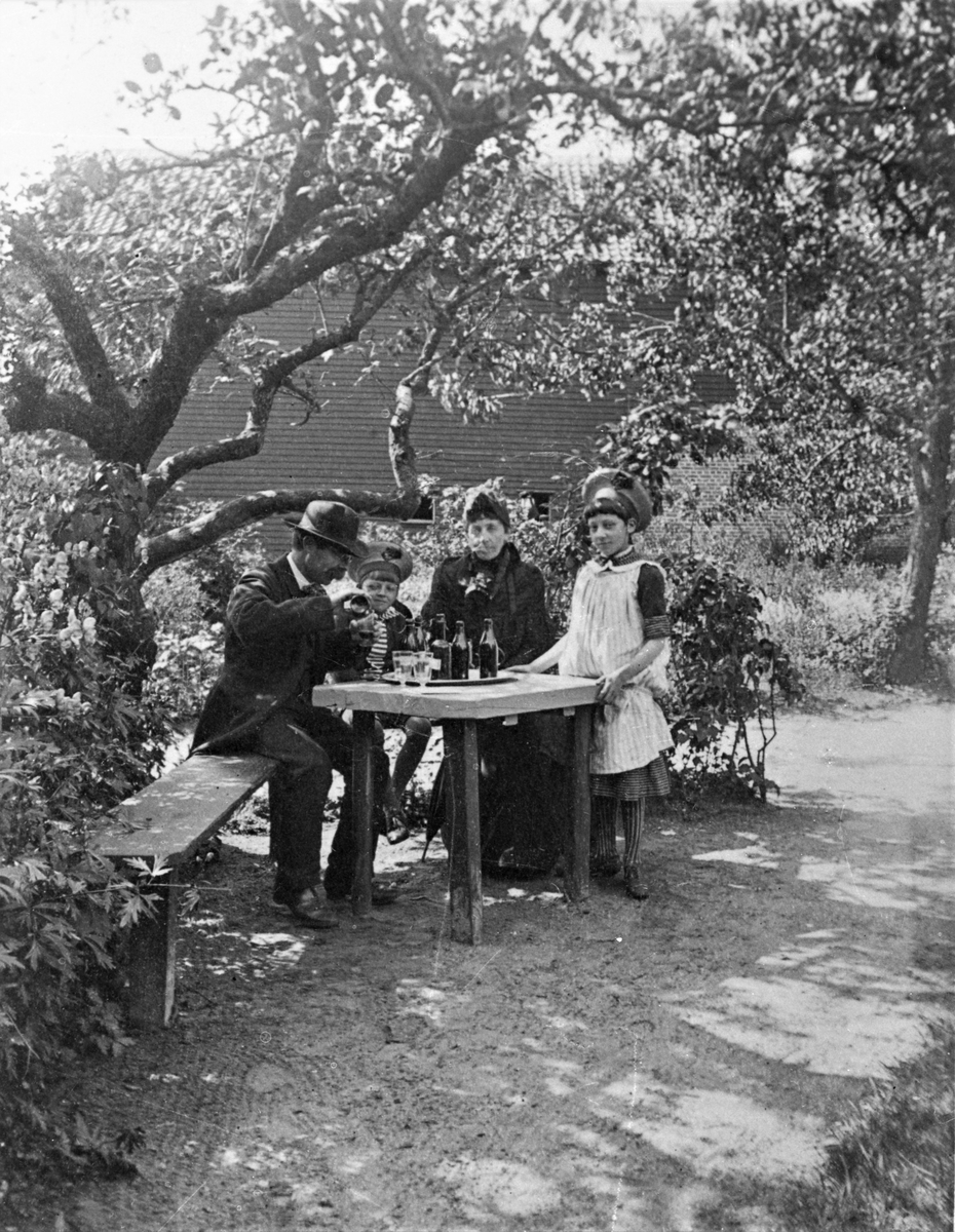 Severin Nilson, hans fru Rosa och de båda barnen Eva och Knut dricker lemonad i värdshuset Hvitans trädgård, Falkenberg.