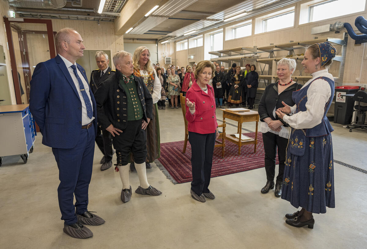 Hennes Majestet Dronning Sonja blir mottatt av magasinforvalter Toril Skaraas Hofseth og gjenstandskonservator Vigdis Vingelsgaard fra Anno museum ved inngangen til konserveringsverkstedene.