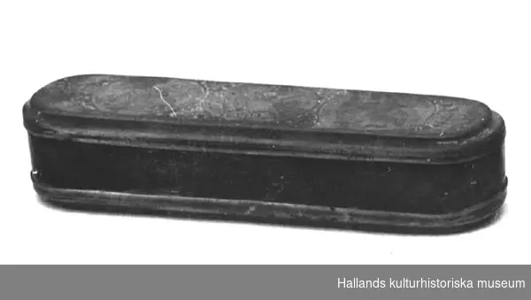 Avlång dosa med rundade hörn och fällock. Lock och botten i mässing och sidor i koppar. Dekorerad i reliefteknik. På locket tre ringar. I mitten ett vapen och vid sidorna porträtt på en man respektive en kvinna. Även växtornament. I botten två stadsvyer från Lissabon, flera mansfigurer, bla en med treudd och en med klot, samt växtornament. Signerad "Giese". 