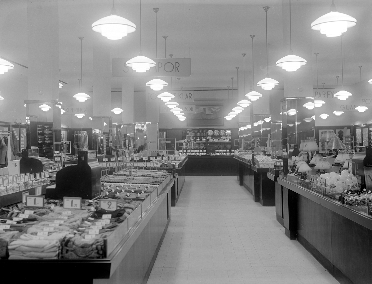 Det elektriska ljuset flödar över varuhuset Tempos breda sortiment. Konfektion, husgeråd och smycken är några urval från denna del av affärshuset. Bild i samband med varuhusets invigning 1935.