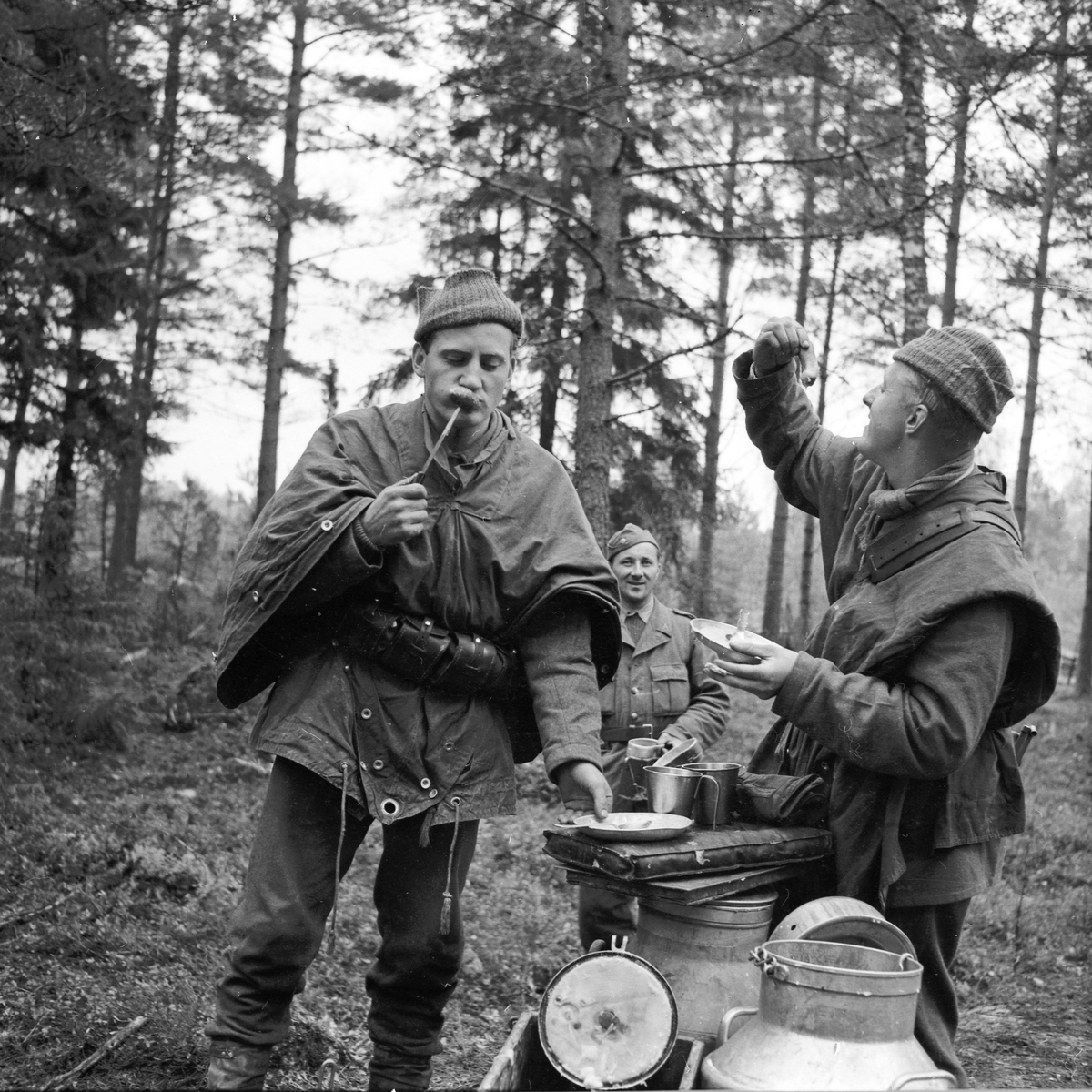 Tre soldater från Hälsinge Regemente, I 14, vid matbespisningen i skogen