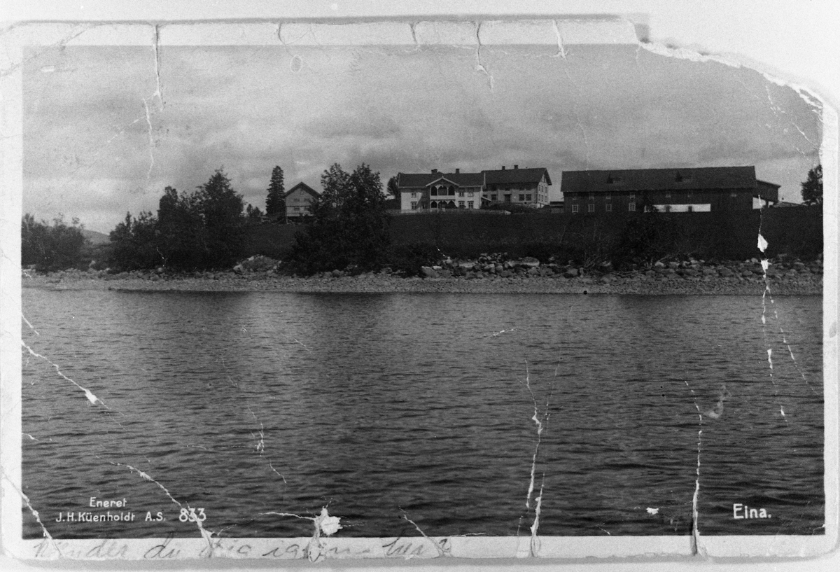 Postkort med motiv fra Eina, Vestre Toten, ca. 1920. Gården Sund sett fra fjorden. Bygningen til venstre for låven er Gamlehjemmet, senere Sund Kurs- og Feriested.