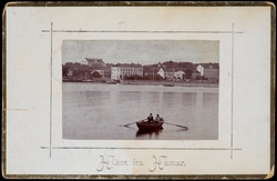 Postkort, Hamar, 2 menn i en robåt i Hamarbukta, med byen i 