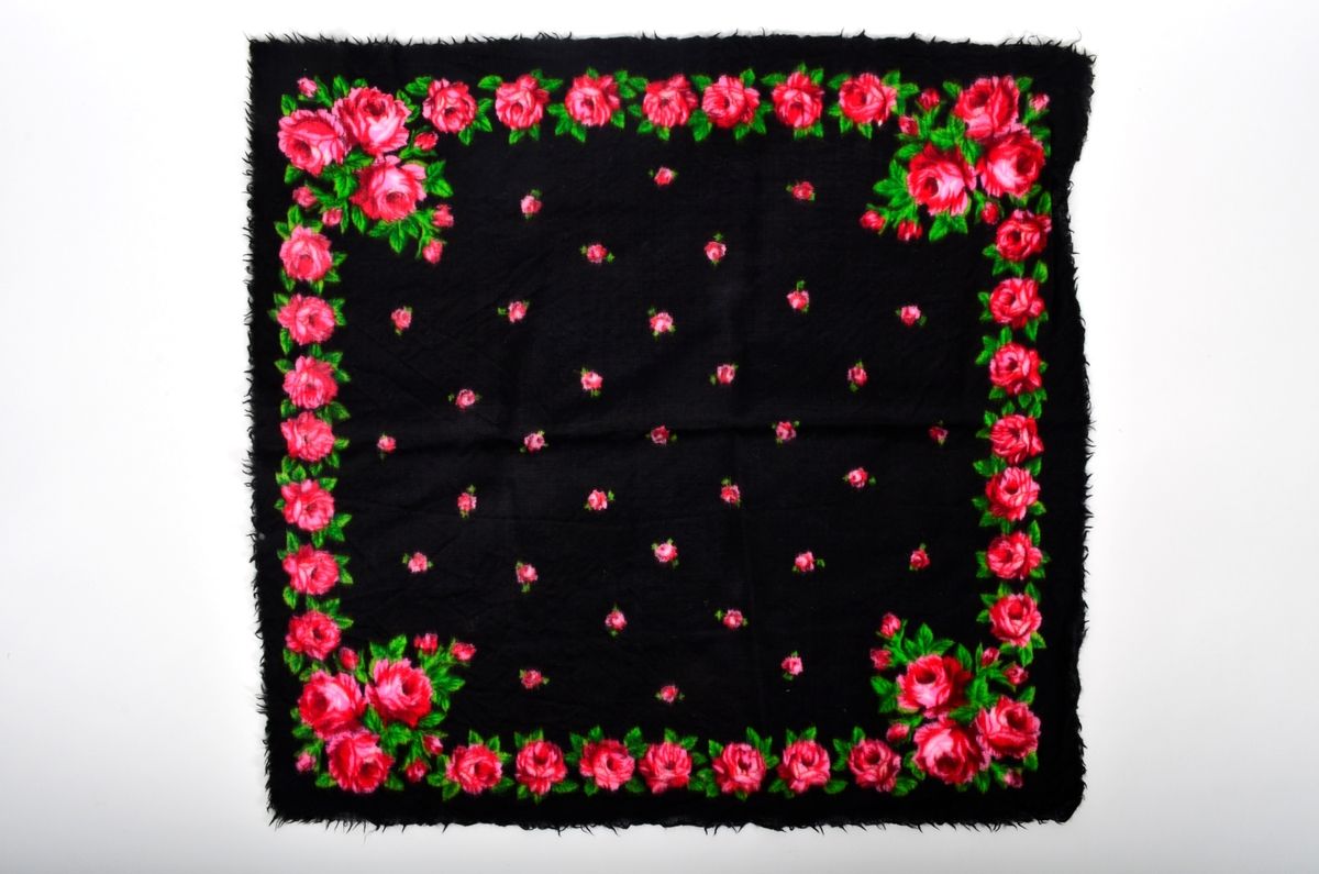 Kvadratisk tørkle eller sjal i svart ull, med påtrykt rosemønster.