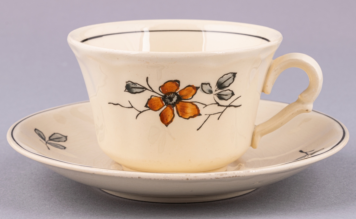 Kaffekopp med fat, i flintgods. Modell AK, dekor Bibo. Vit glasyr med flerfärgat blommönster. Skapad av Eugen Trost för Gefle Porslinsfabrik 1936.