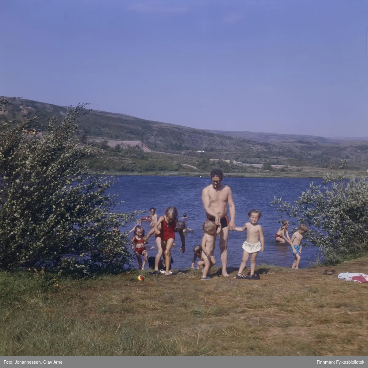 Foto av mann og barn som bader i Jovannet i Båtsfjorddalen

Mann som står i vannet (til venstre) er Eilif Eriksen 

Mann i midten kan være Sveinung Wilsgård (usikker identifisering)

Foto trolig tatt på 1960/70-tallet