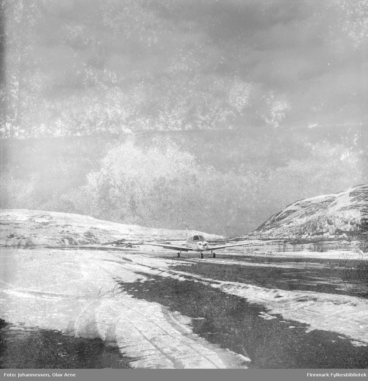 Foto av propellfly på Båtsfjord Flyplass på tidlig 1970-tallet

Flyet er omringet av sne og man ser vinterlandskap i bakgrunnen 