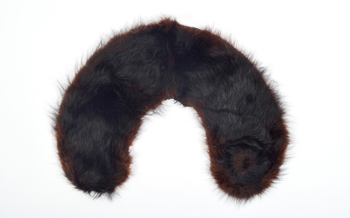 Løs, buet krage i brunsvart pels fôret med svart silkestoff.