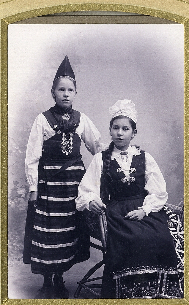 Två systrar i folkdräkter (Rättvik och Värend).
Helfigur, en face. Ateljéfoto.