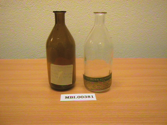 To medisinflasker, en av brunt og en av klart glass, fra Moss Glassverk.