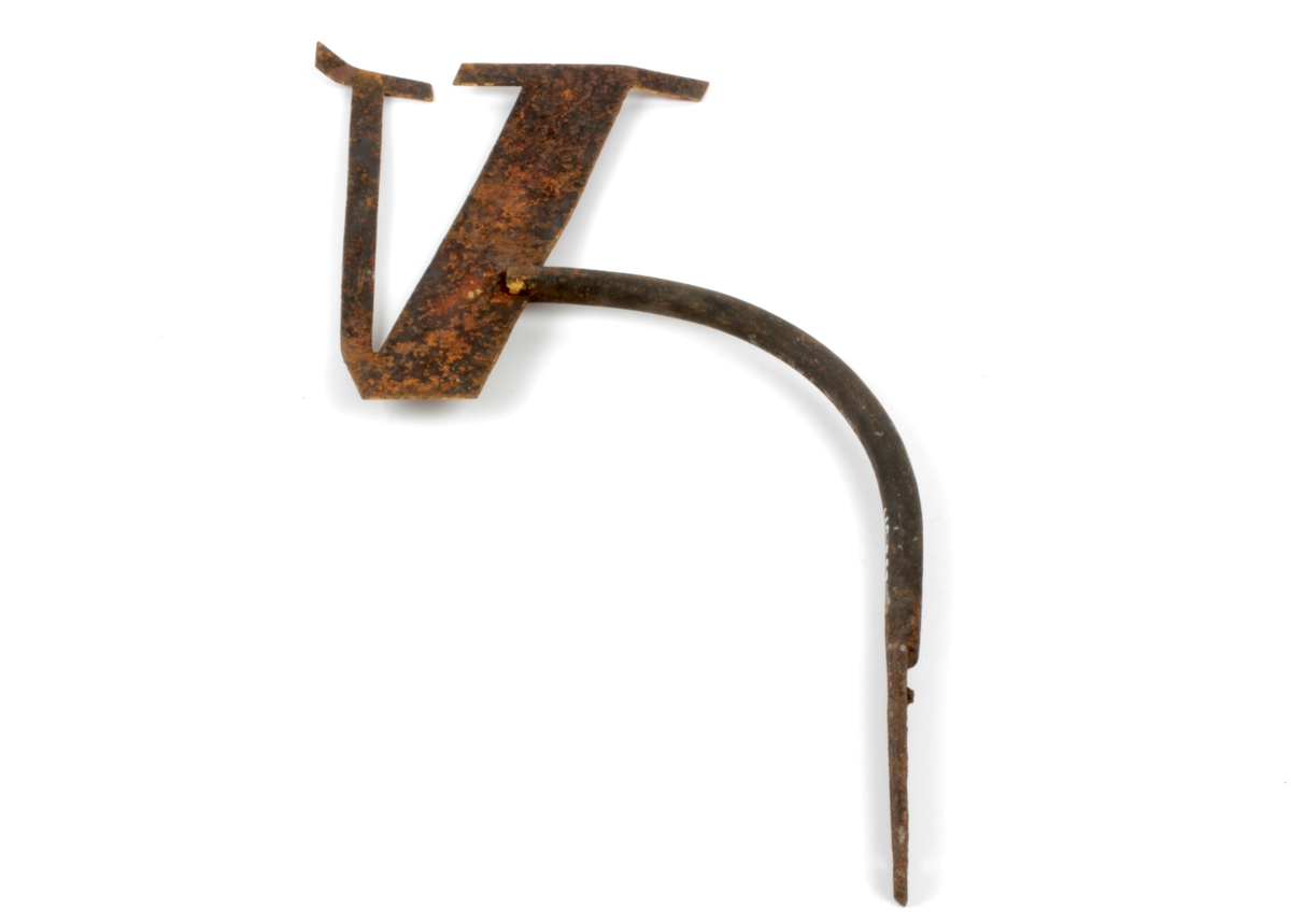 "V" med en tykk og en tynn stolpe festet til buet jern med skruehull nederst - i det ene av disse avrusta skrue. Ukjent bruk

10.05.2012: Spor etter forgylling på underlag som kan være blymønje (orange farge)