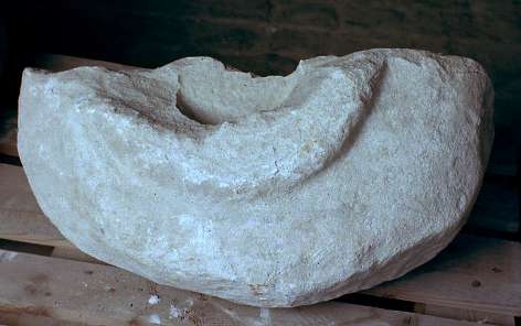 Dopfunt av vitaktig kalksten, bestående av två delar , med brottytor som rundats av ålder, rund skålform utan dekor.

