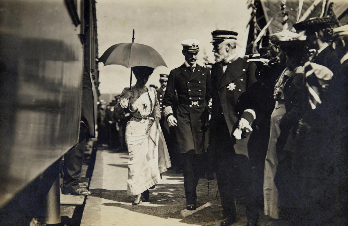 Postkort, Ringsaker, stor folkemengde hilser kong Haakon og dronning Maud velkommen ved Tande stasjon, Ringsaker stasjon. Kroningsreisen til Trondheim den 13. juni 1906, første dag på reisen,