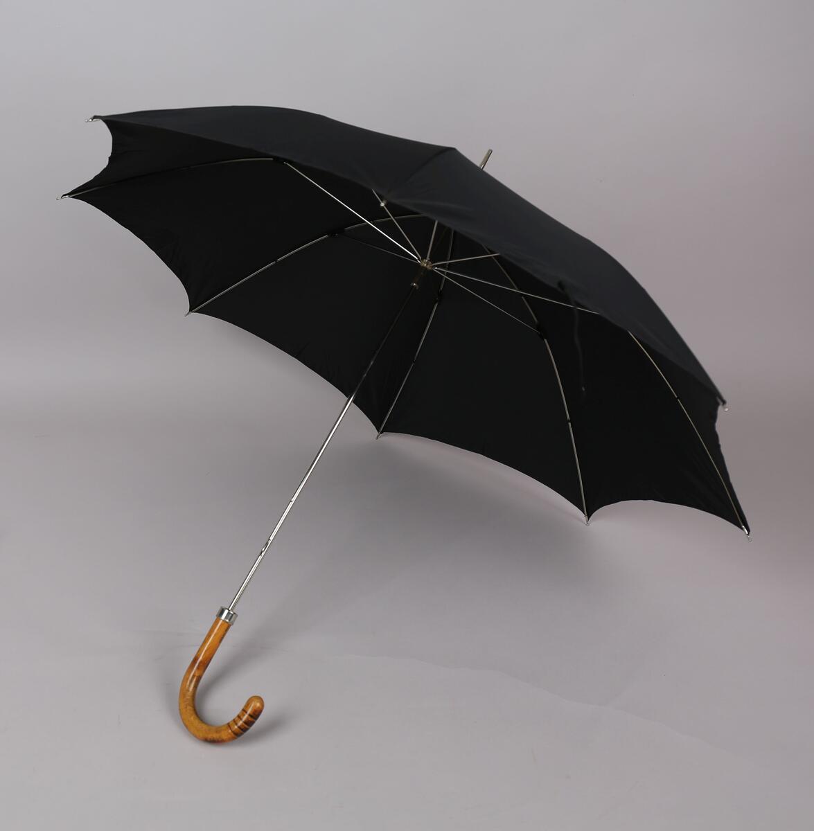 Paraply med 8 spilar og stong i metall. Handtak i tre.