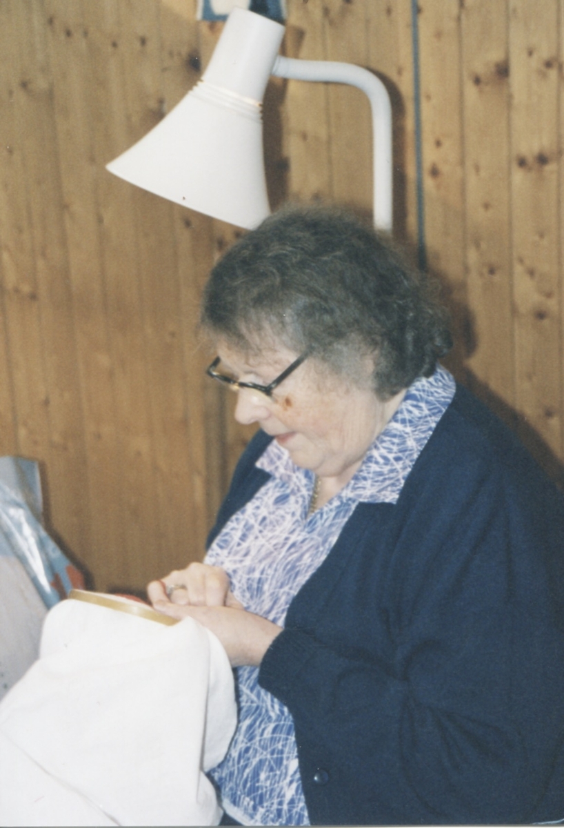 Rose-Maj Ekström (född Benkel) sitter på en stol och broderar, Missionskyrkan, okänt årtal.