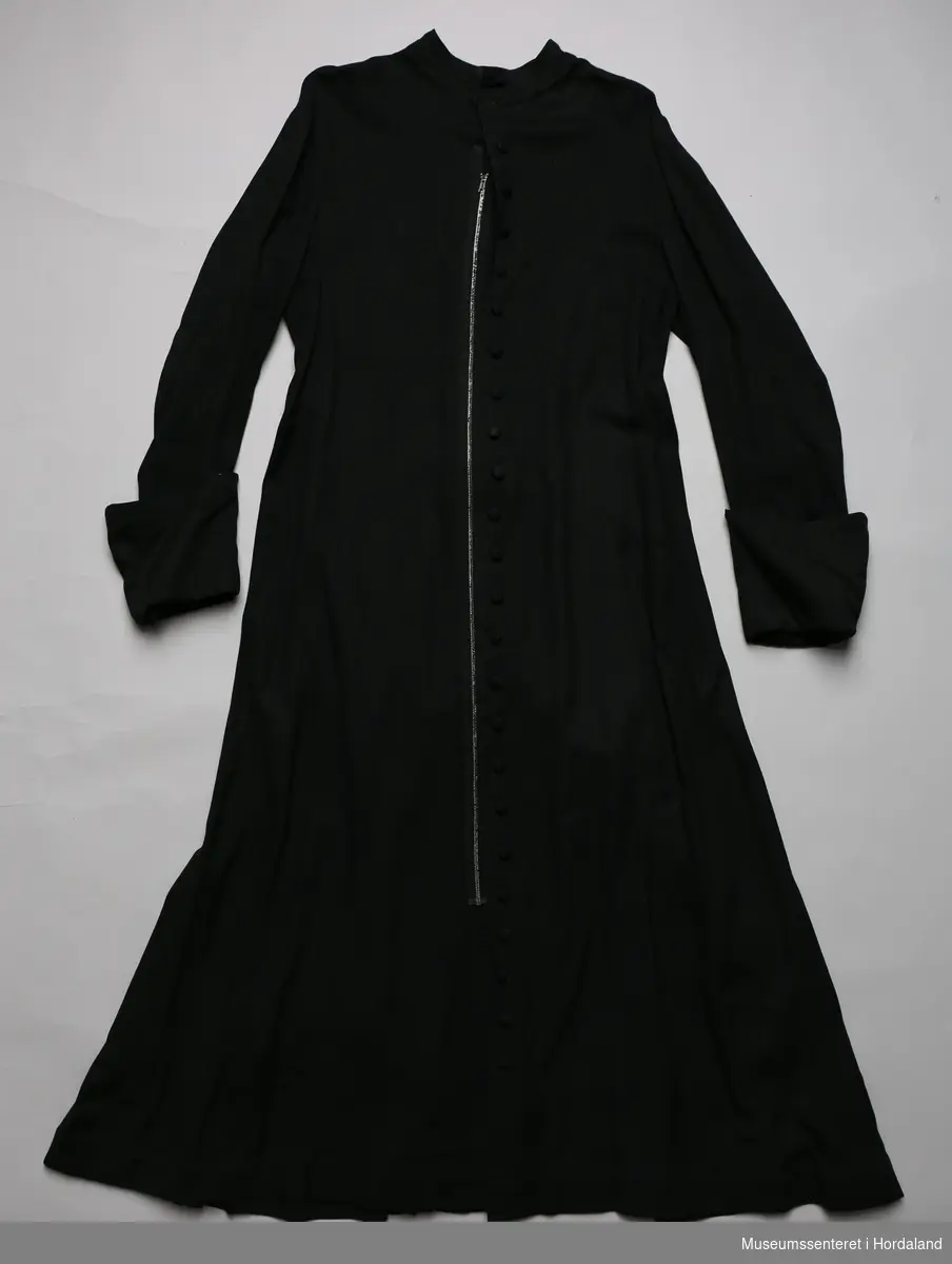 Et sett med messeklær bestående av svart prestekjole og hvit messeskjorte.