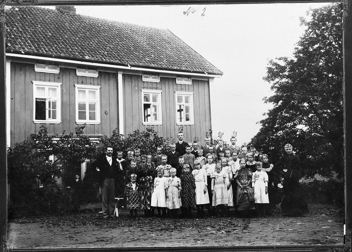 Gruppebilde med en rekke barn og unge samlet på gårdsplassen på ...
