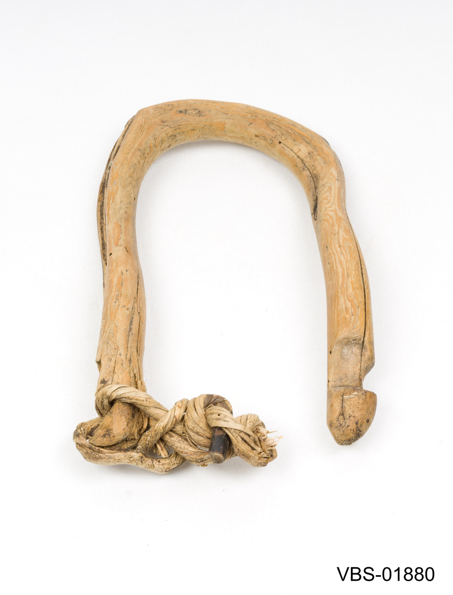 Laget av en hel einergrein, brettet i hesteskoform.
Rester av tau i knutet vegetabilsk fiber på den ene siden.