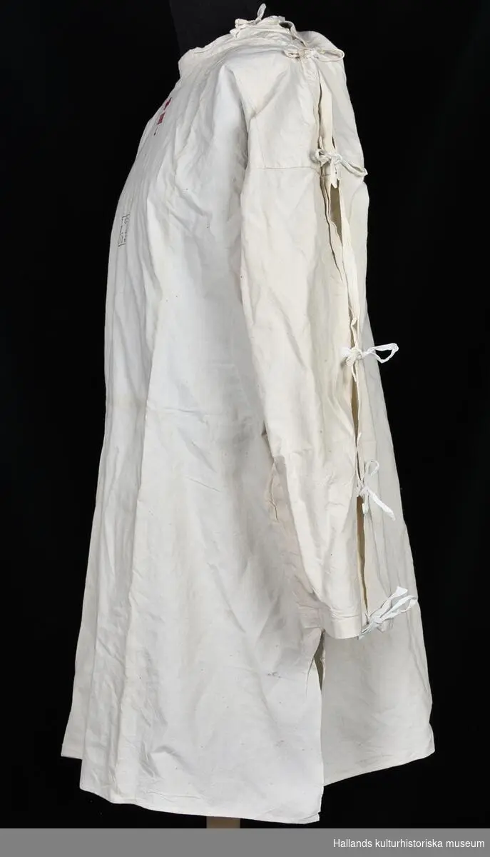 Skjorta av grovt vitt bomullstyg. Kraglös rund halsurringning. Skjortan Förseglas med 6 par snören längs vänster ärm. Vid bröstet finns en brodering i röd bomullstråd i form av ett rött kors samt bokstäverna "HH", "L". På bröstet finns även stämpel i svart bläck bestående av två rader tecken: "l. 16" och "L.0.8b", samt en krona.