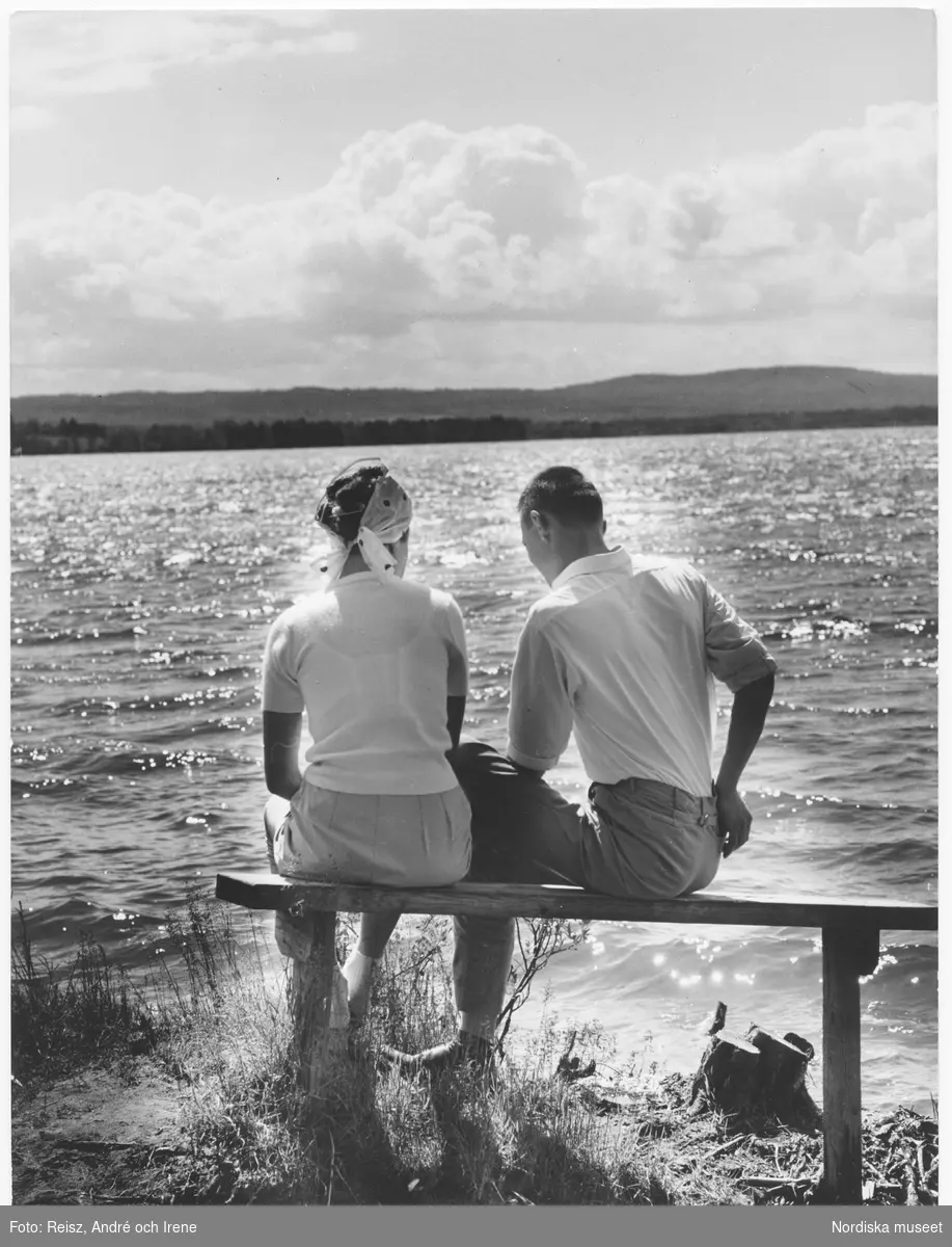 Dalarna. Afton i Rättvik vid Siljan. Ett par på en bänk i strandkanten.
