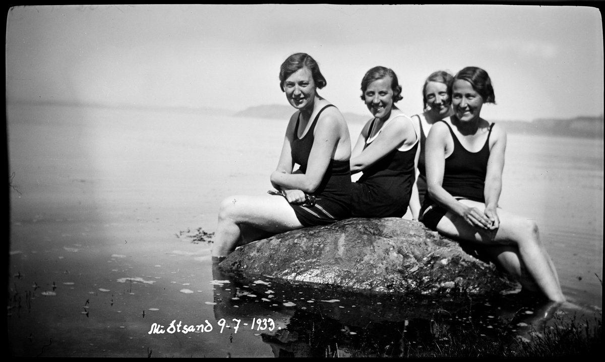 Kvinner på en stein i sjøen
