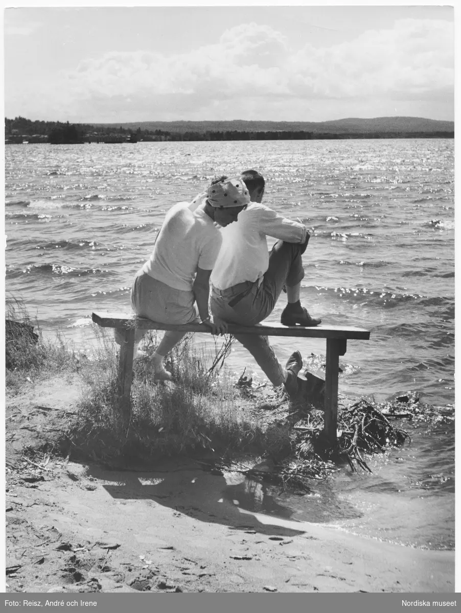 Dalarna. Afton i Rättvik vid Siljan. Ett par sitter på en bänk alldeles vid vattnet.