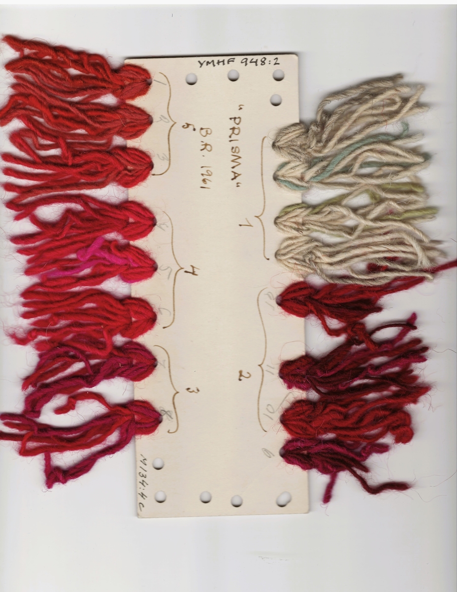 Färgskiss och garnprov till matta i röllakansteknik i olika röda och naturfärgade nyanser, fastklistrad på kartong. Signatur finns på själva kartongen. Skissen är gjord på ritpapper i akvarellfärg