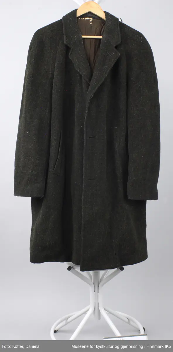 Frakken er av solid, mørkegrå ytterstoff som ligner på vadmel. Inne har frakken en for av silkeaktig, mørkebrunt stoff.  Den lukkes med runde knapper.