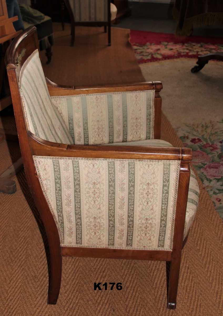 Samme stol som K175, men en del detaljer er forskjellige: Lenet har en profil tvers over nesten i forkant. Lenets tverrsnitt er litt mindre flattrykt, og benene ender på et liggende ovalt stykke. Høyere lener. Venstre bakben er nytt.
Sees også på AAM E 1339.