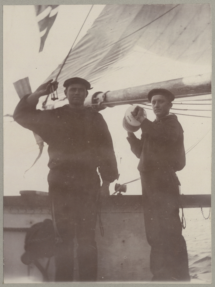 Två sjömän presenterar utrustningen för att mäta fartygets hastighet, timglas och knopsnöre.