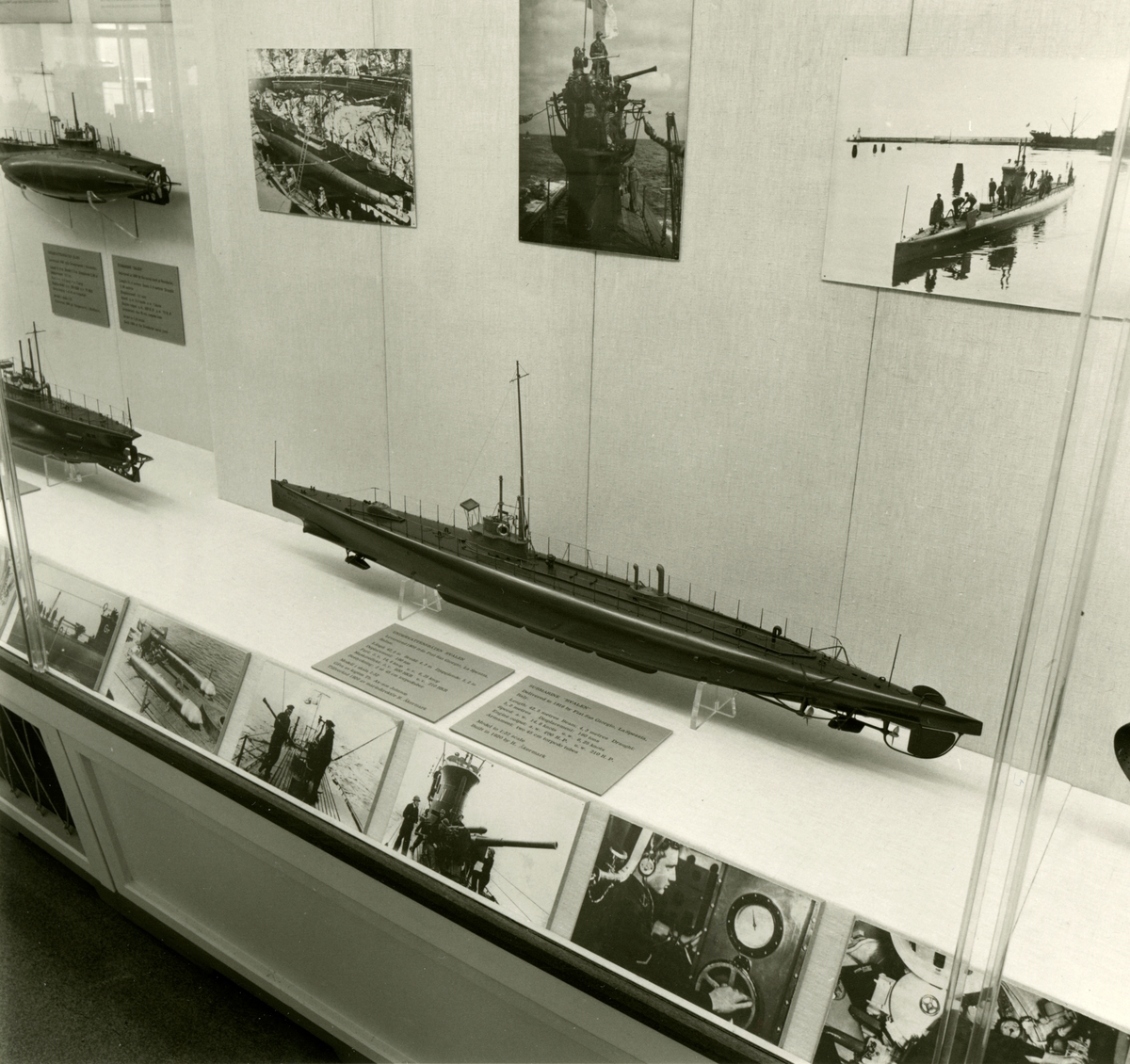 Den permanenta utställningen fotograferad 1987. Monter med fotografier och text om ubåtsverksamhet. Fartygsmodeller av ubåtarna HVALEN och HAJEN.