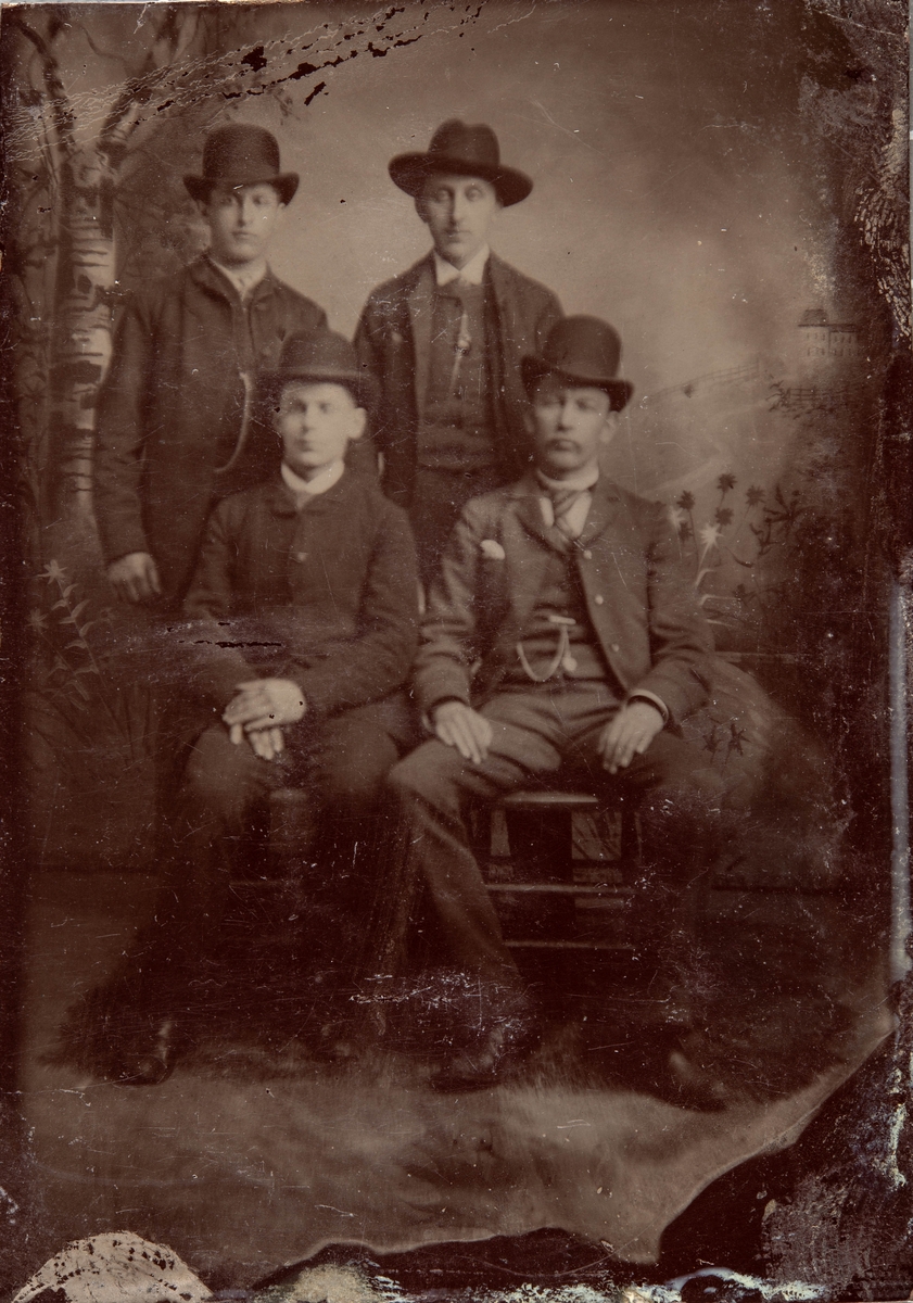Studioportrett av fire menn med hatt.