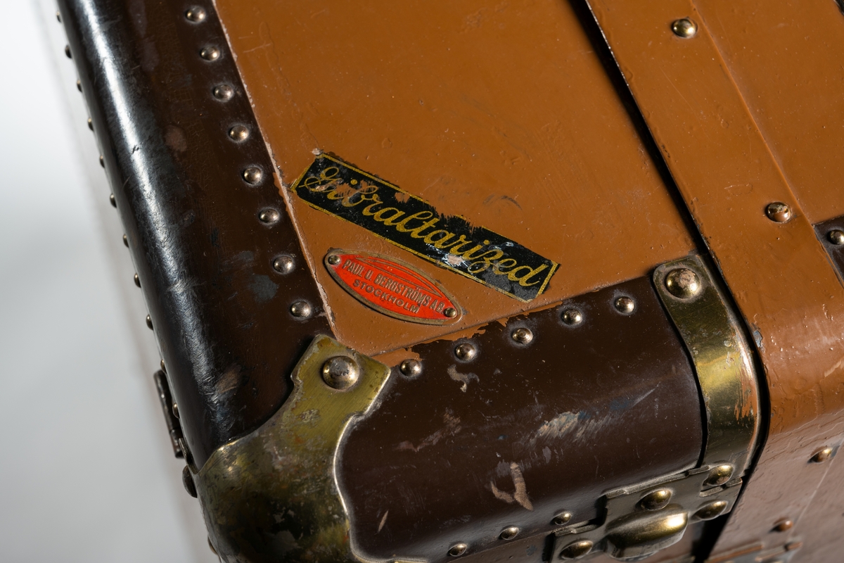Koffert, resegarderob av märket Hartmann, av brun kartongpapp med metallbeslag och nitade förstärkningar runt kanterna. Kofferten består av två delar med ett uppfällbart lock upptill på en kortsida, invändigt klätt med gul-brun sammet. Den nedfällbara delen innehåller fyra fack med bruna knytband av bomull, och mönstervävt gul-brunt tygöverdrag. Den upprättstående delen, för hängande kläder, har sju galgar (tre modeller), varav en något skadad. Ett tvärgående band av sammet finns för att hålla kläderna på plats. Kofferten är låsbar. Handtag av läder finns på en kortsida och en långsida. Märke med flera patent sitter på en av kortsidornas insida.

På kofferten finns flera märken:
HARTMANN TOUROBE WARDROBE CASE Made in Racine, Wis., USA Reg. US. Pat. Office / Gibraltarized 
PAUL U. BERGSTRÖMS AB. STOCKHOLM
Nycklar och lås är präglade: 
YALE & TOWNE MFG.CO / MADE FOR HARTMANN H 40 I / MADE BY YALE